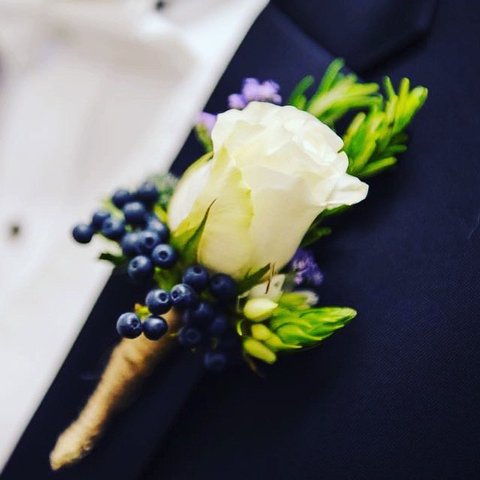 White rose boutonniere with blue berries