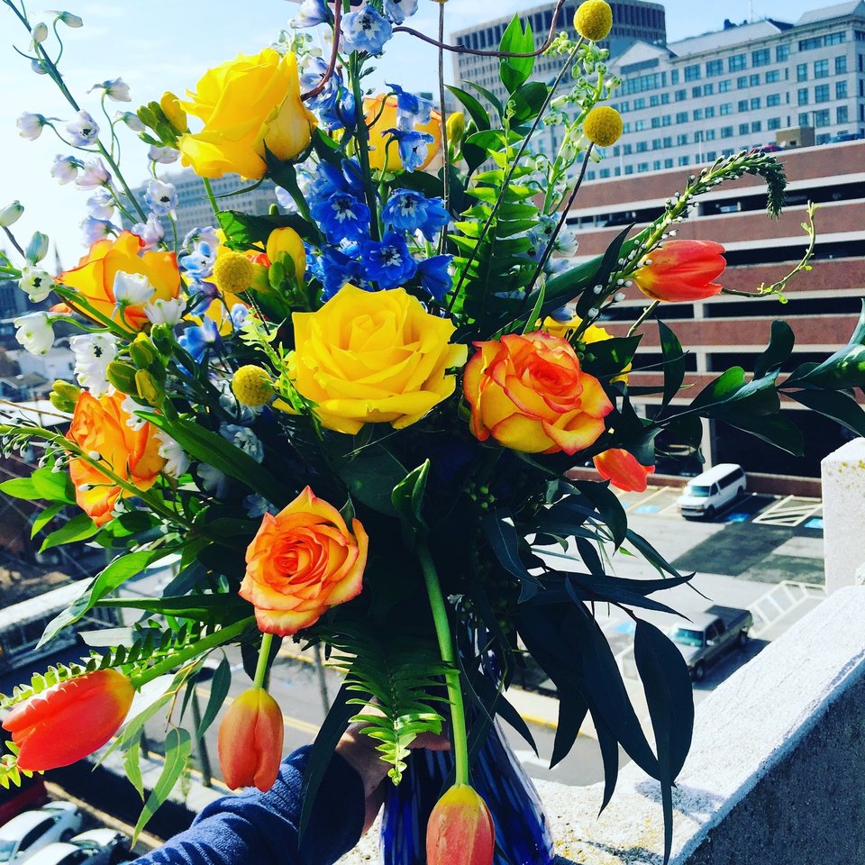 Bouquet of yellow and orange roses with blue flowers