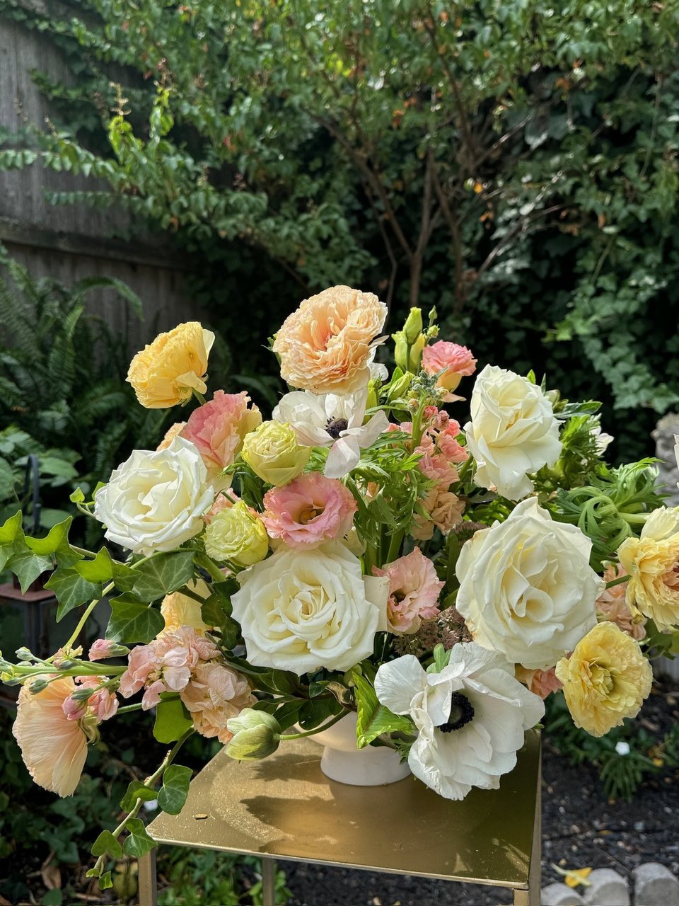 Peach, cream, and yellow garden arrangement on a gold stand