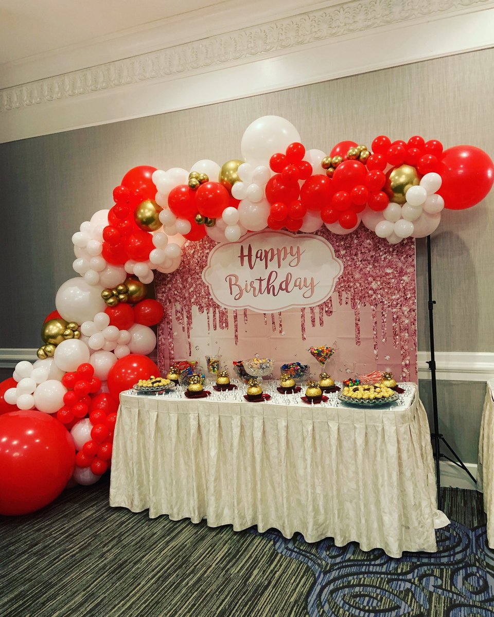 Red, white, and gold balloon garland around a Happy Birthday dessert table