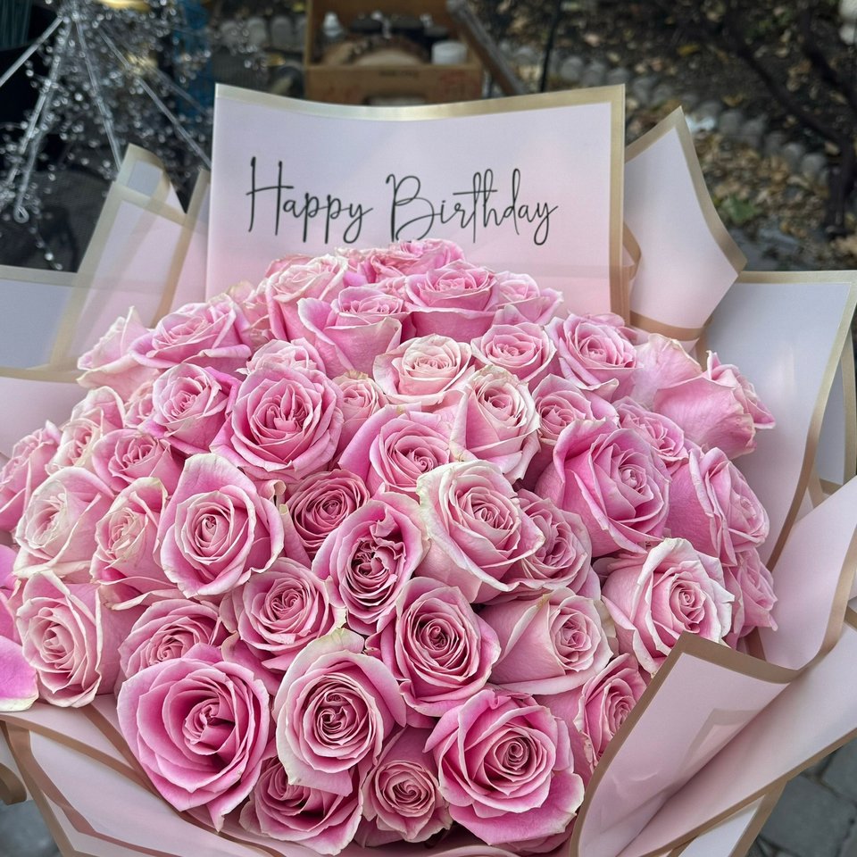 Large bouquet of pink roses with a Happy Birthday card
