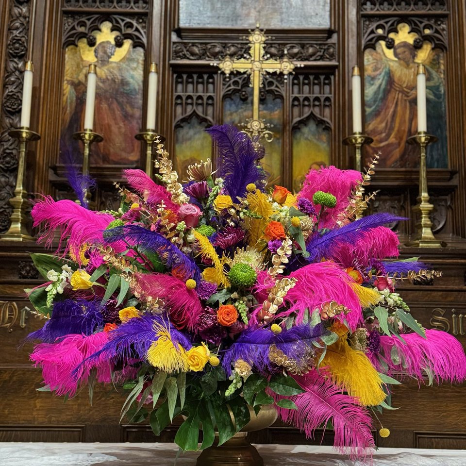 Altar arrangement with bright feathers and flowers