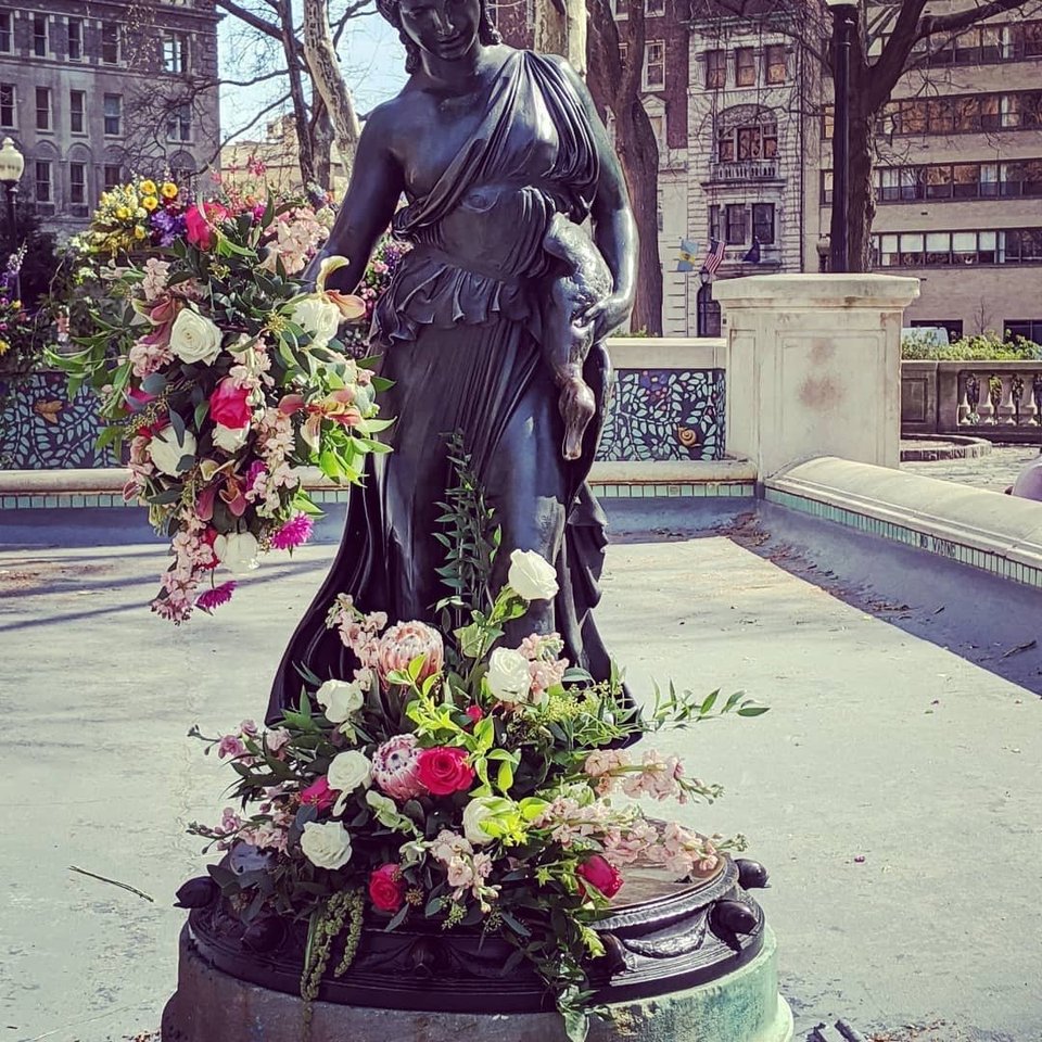Statue dressed with pink and white flowers