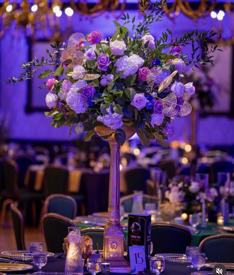 Purple and lavender centerpiece in a tall vase
