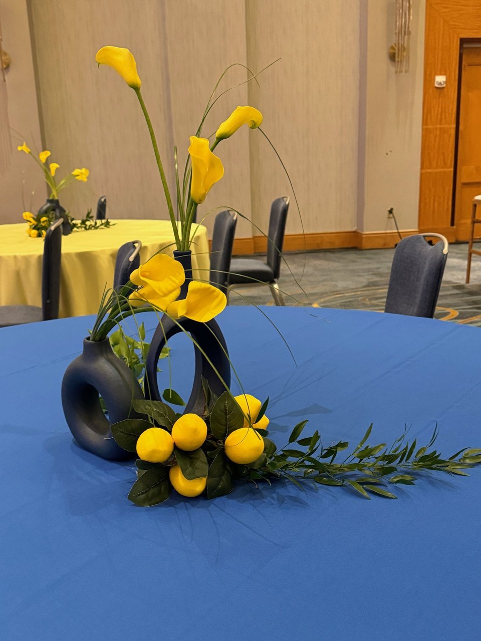 Yellow calla lilies and lemons in a sculptural vase