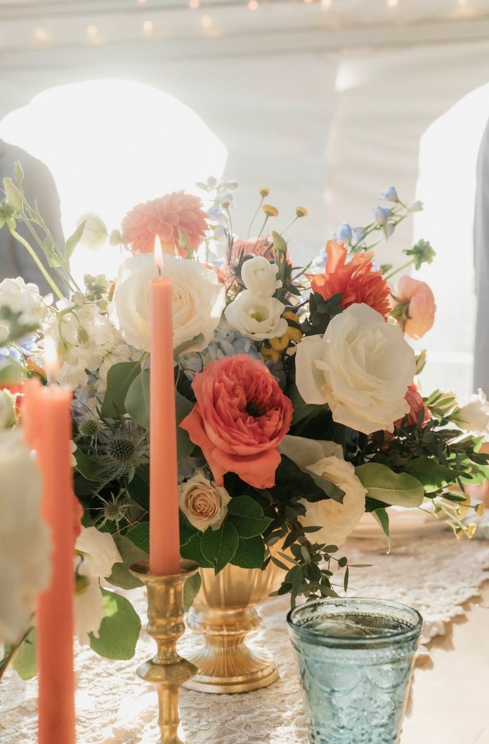 Coral and white centerpiece with taper candles